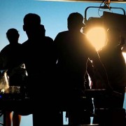 Multiple people in silhouette in front of stage lights